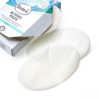 Weiße, ovale Balea Achselpads in Größe L vor der geöffneten Produktverpackung auf weißem Hintergrund.