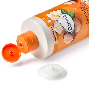 Balea Locken Spülung 350ml in orangefarbener Flasche mit Macadamiaöl, Sheabutter und einem Klecks weißer Conditioner-Creme.