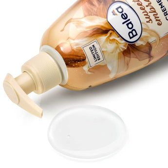 Balea Cremeseife Sweet Embrace 500 ml in goldener Flasche mit Pumpspender und einem Tropfen transparenter Flüssigseife.