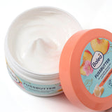 Geöffneter Tiegel Balea Fußbutter mit weißer Creme, pfirsichfarbenem Deckel und Pfirsich-Design auf weißem Hintergrund.