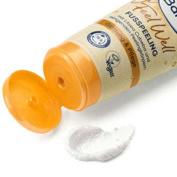 Geöffnete Tube Balea Fußpeeling Feel Well mit cremiger Textur und orangefarbenem Verschluss auf weißem Hintergrund.