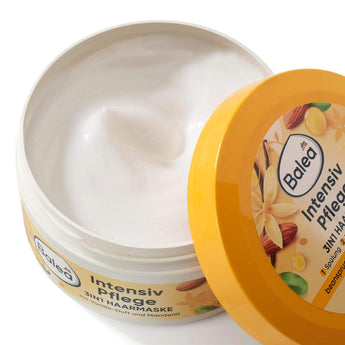 Geöffnete Balea Intensivpflege 3in1 Haarmaske mit weißer Creme, gelbem Deckel und Mandel-Vanille-Design auf weißem Grund.