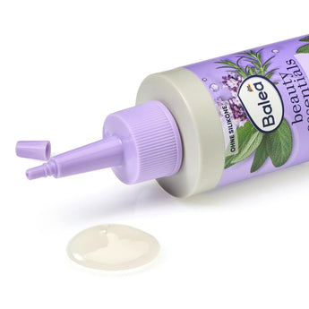 Balea Kopfhaut Tonikum in einer violetten Flasche mit Applikatorspitze und einem Tropfen des klaren Tonikums auf weißem Grund.