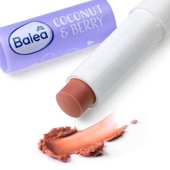 Balea Lippenpflegestift Coconut & Berry in lila Hülse mit beigem Balsam und einem Swatch auf weißem Hintergrund.