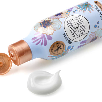Hellblaue LANGHAARMÄDCHEN Conditioner-Flasche mit Blumenmuster, kupferfarbenem Deckel und weißer Cremetextur.