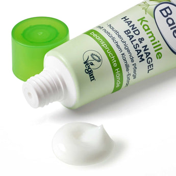 Balea Kamille Hand- und Nagelbalsam in der 30 ml Tube mit grünem Deckel und einem Klecks weißer Creme auf weißem Hintergrund.