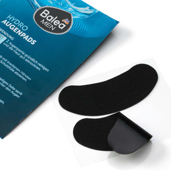 Zwei schwarze Balea MEN Hydro Augenpads auf einer transparenten Trägerfolie neben der blauen Produktverpackung.